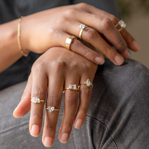 Model wearing eight lag grown white diamond engagement rings with crossing hands