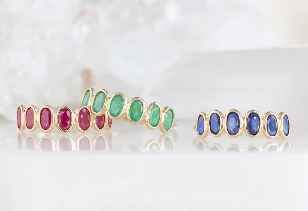 Ruby, Gemstone and Sapphire Gemstone Eternity Rings on white marble tile