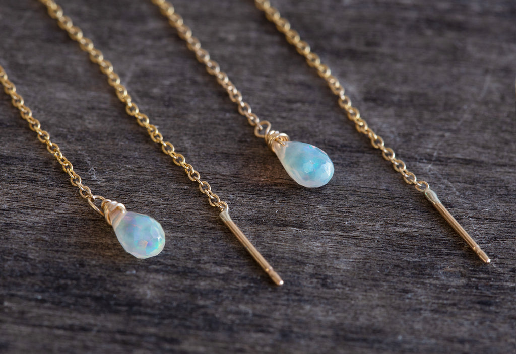 close up of Natural Opal Thread Earrings on wood table