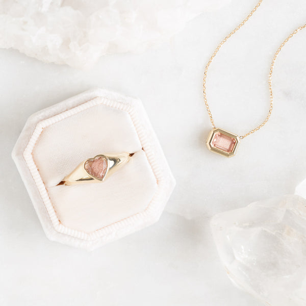 Sunstone Signet Ring and Necklace on White Marble Slab