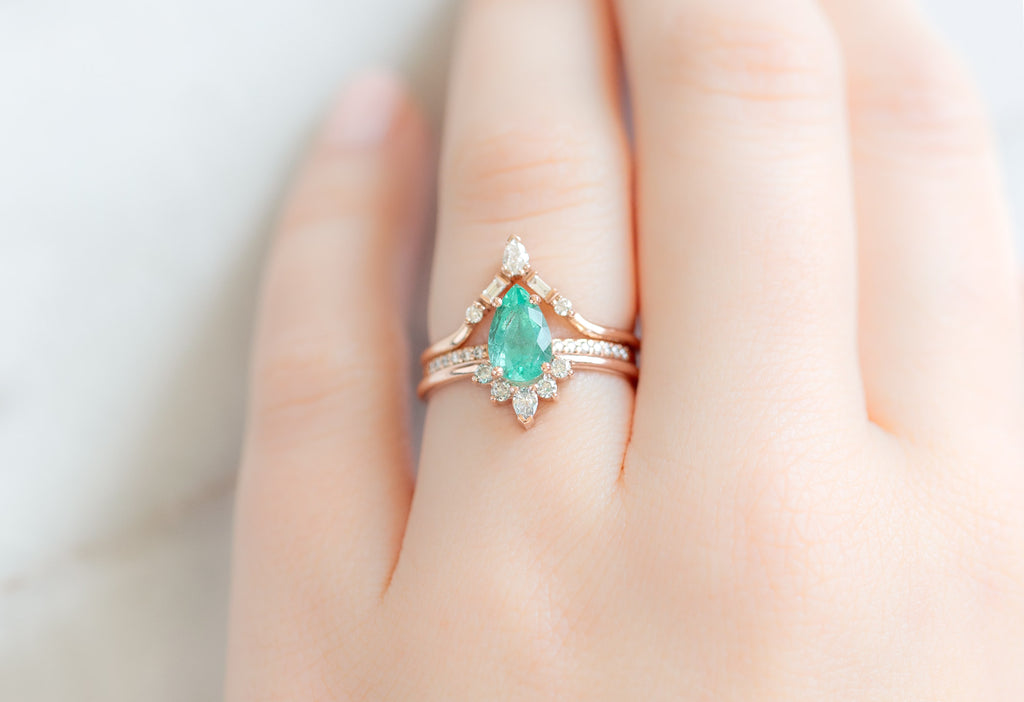 The Aster Ring with a Pear-Cut Emerald with Stacking Bands on Model