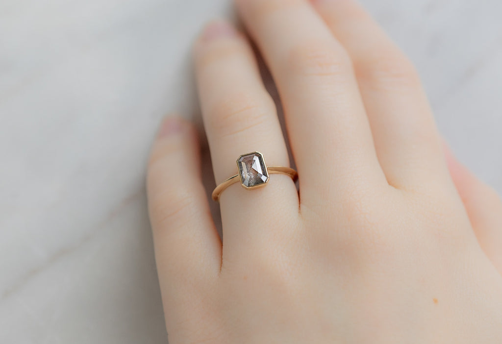 The Hazel Ring with an Emerald-Cut Salt and Pepper Diamond on Model