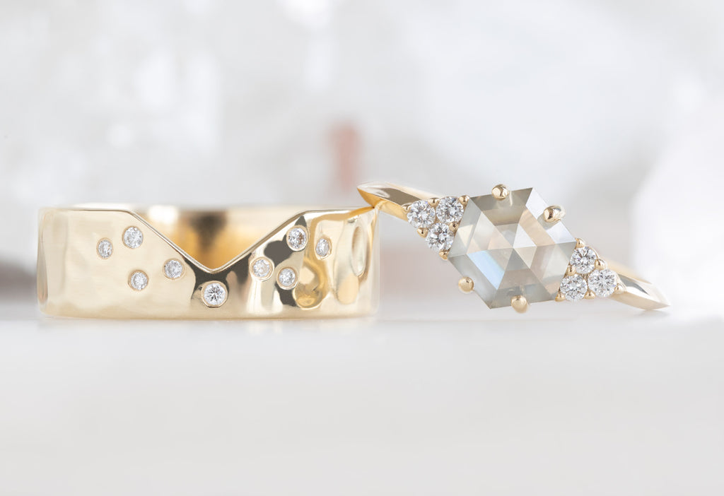 The Ivy Ring with a Green Hexagon Diamond leaning on The Constellation Cut-Out Stacking Band
