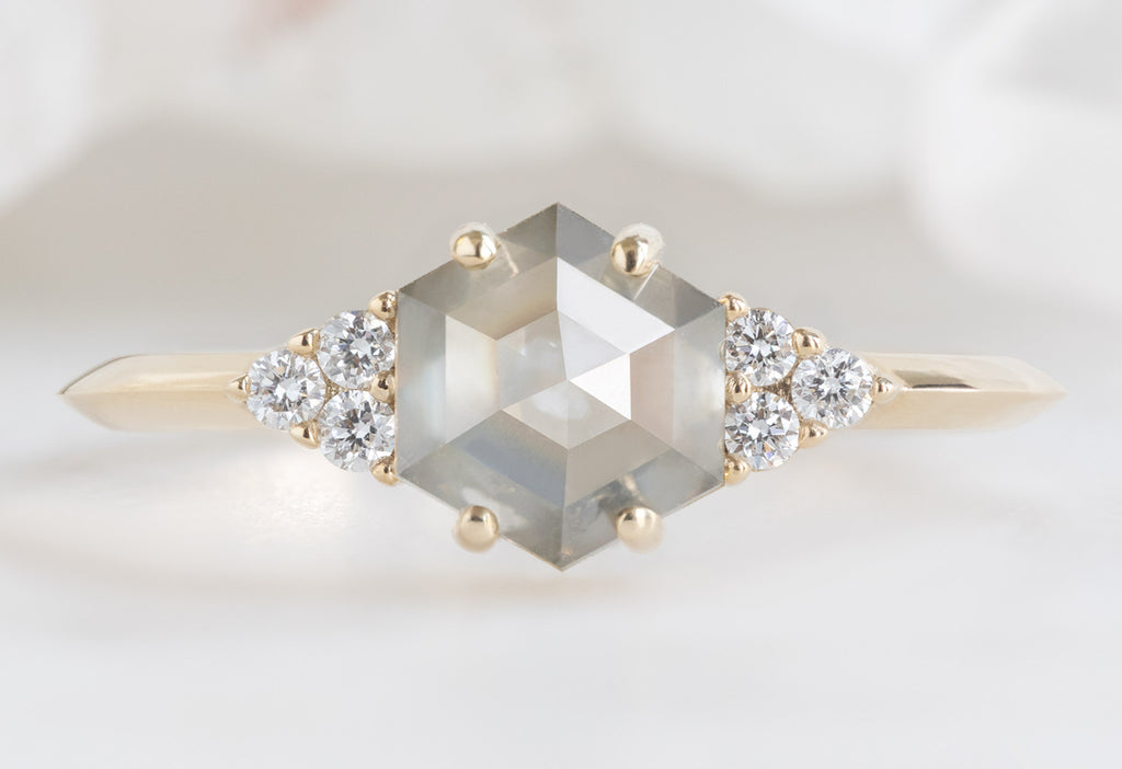 The Ivy Ring with a Green Hexagon Diamond on White MArble Tile